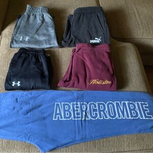 Five pairs of boys athletic pants (Under Armour, Puma, Hollister, Abercrombie)